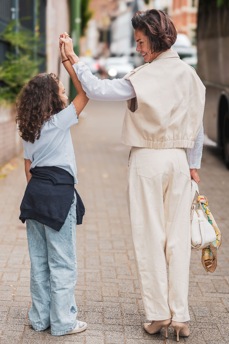 Woman and child holding hands on a street