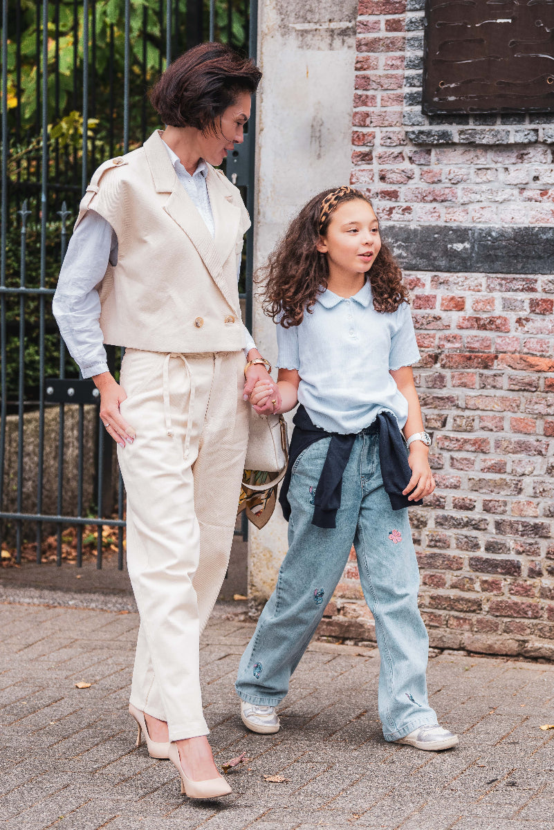 Woman with beige vest walk with daughter 