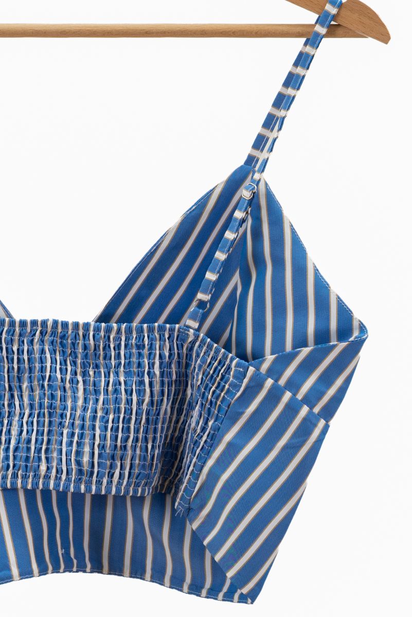 Blue and white striped top on a hanger against a white background